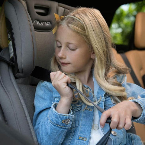 Nuna EXEC older girl buckling self into seat